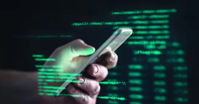 Darkweb, darknet and hacking concept. Hacker with cellphone. Man using dark web with smartphone. Mobile phone fraud, online scam and cyber security threat. Scammer using stolen cell. AR data code. terovesalainen - stock.adobe.com
