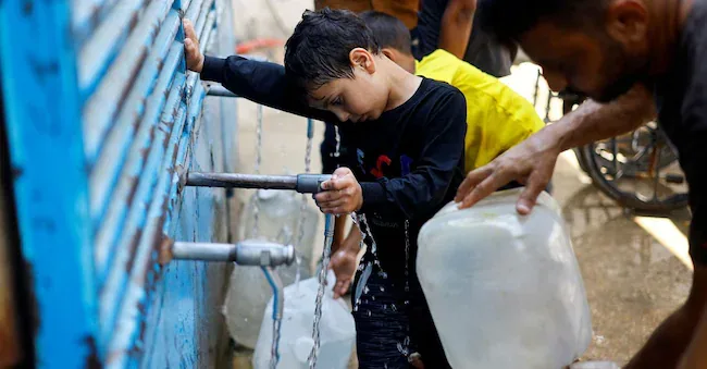 Palestinians fill water jerrycans at a water distribution point in Nuseirat, central Gaza Strip, on July 15, 2026. REUTERS/Mahmoud Issa     TPX REUTERS PICTURES OF THE DAY