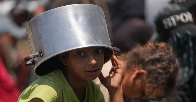 A displaced Palestinian girl waits to receive donated food at a community kitchen in Khan Younis, in the southern Gaza Strip, Thursday, July 23, 2026. (AP Photo/Abdel Kareem Hana) Associated Press/ LaPresse Only Italy and Spain APN