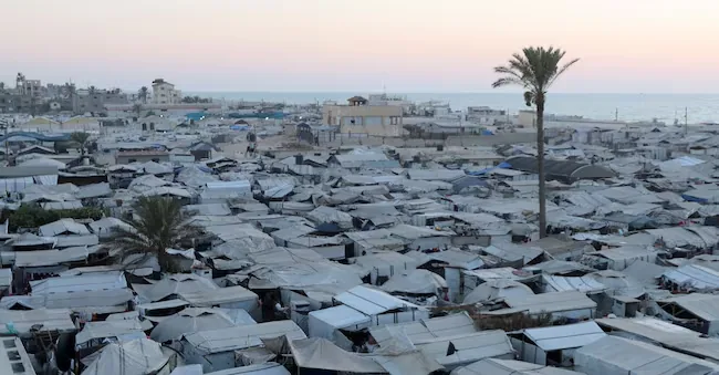 Displaced Palestinians find refuge in a tent camp, in a context characterized by a shortage of lighters and cooking gas that has forced many families to resort to wood fires for cooking, in Khan Younis, in the southern Gaza Strip, July 21, 2026. REUTERS/Ramadan Abed REUTERS