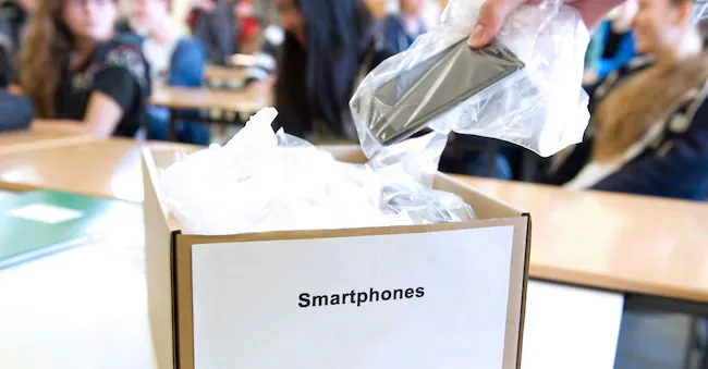 IPP/picture alliance/Sebastian Kahnert photo showing students' mobile phones and smartphones being collected inside a school classroom before the lesson begins - - Italy Photo Press - IPP