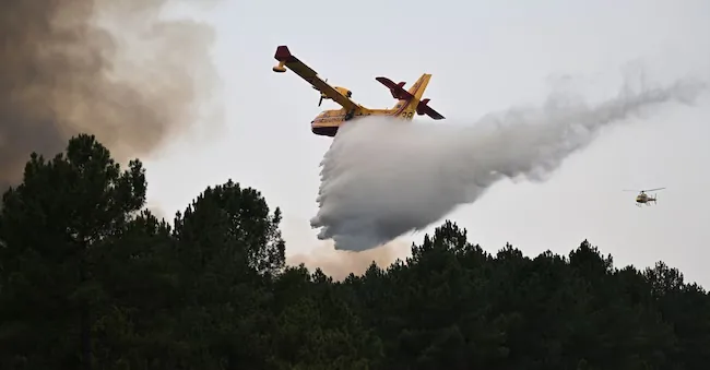 A plane releases its water tank on a fire near Saint-Jean-d'Illac, during the wildfires in southwestern France, Tuesday, July 28, 2026. (AP Photo/Emma Da Silva) Associated Press / LaPresse Solo Italia e Spagna APN