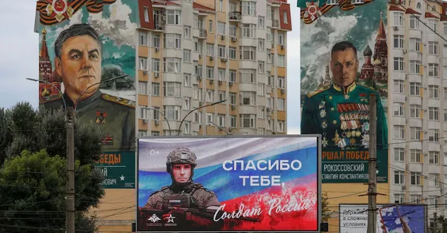 A screen on which a patriotic military illustration is projected, in the context of the Russian campaign against Ukraine, is located in front of residential buildings depicting Soviet commanders Konstantin Rokossovsky and Alexander Vasilevsky in Simferopol, Crimea (REUTERS)